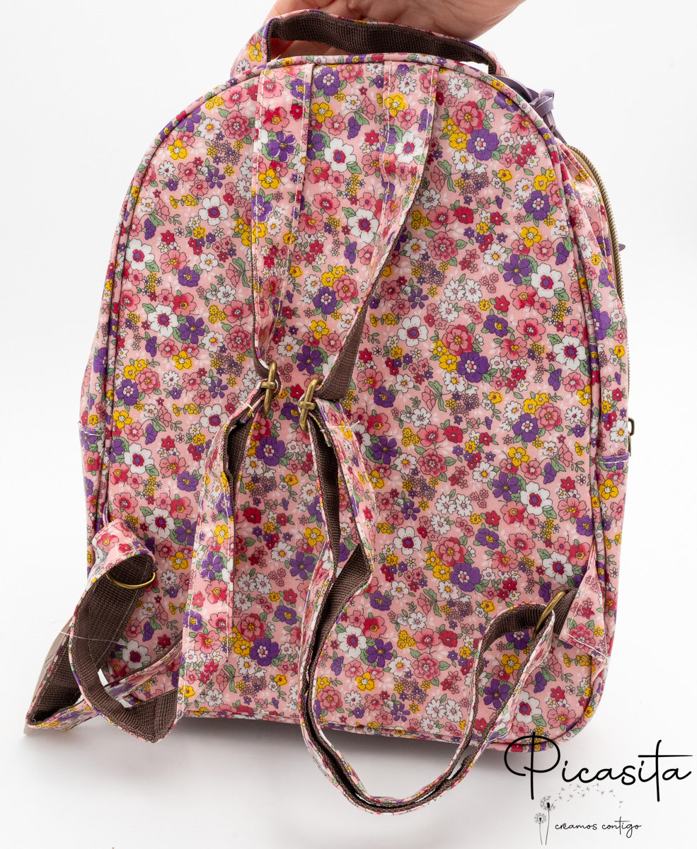 Parte posterior de la mochila con correas ajustables y asa superior de color marrón.