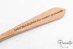 Detalle macro del mensaje de enhorabuena grabado sobre el veteado natural de la madera.