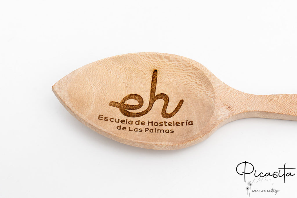 Detalle del grabado láser con logotipo de escuela de hostelería en la pala de una cuchara.
