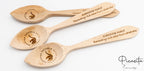 Tres cucharas de madera grabadas con mensajes de agradecimiento y logotipos de concursos culinarios.