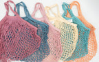 Conjunto de seis bolsas de malla de colores alineadas mostrando la variedad cromática disponible.