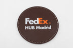 Runder brauner Untersetzer mit farbigem FedEx-Logo.