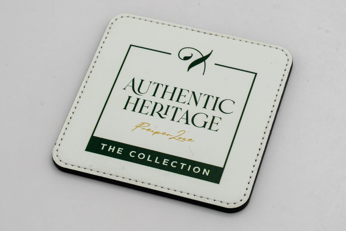 Quadratischer weißer Untersetzer mit grünem Authentic-Heritage-Logo.