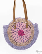 Bolso redondo de rafia tejida en tonos violeta y rosa con asas de cuero PU.