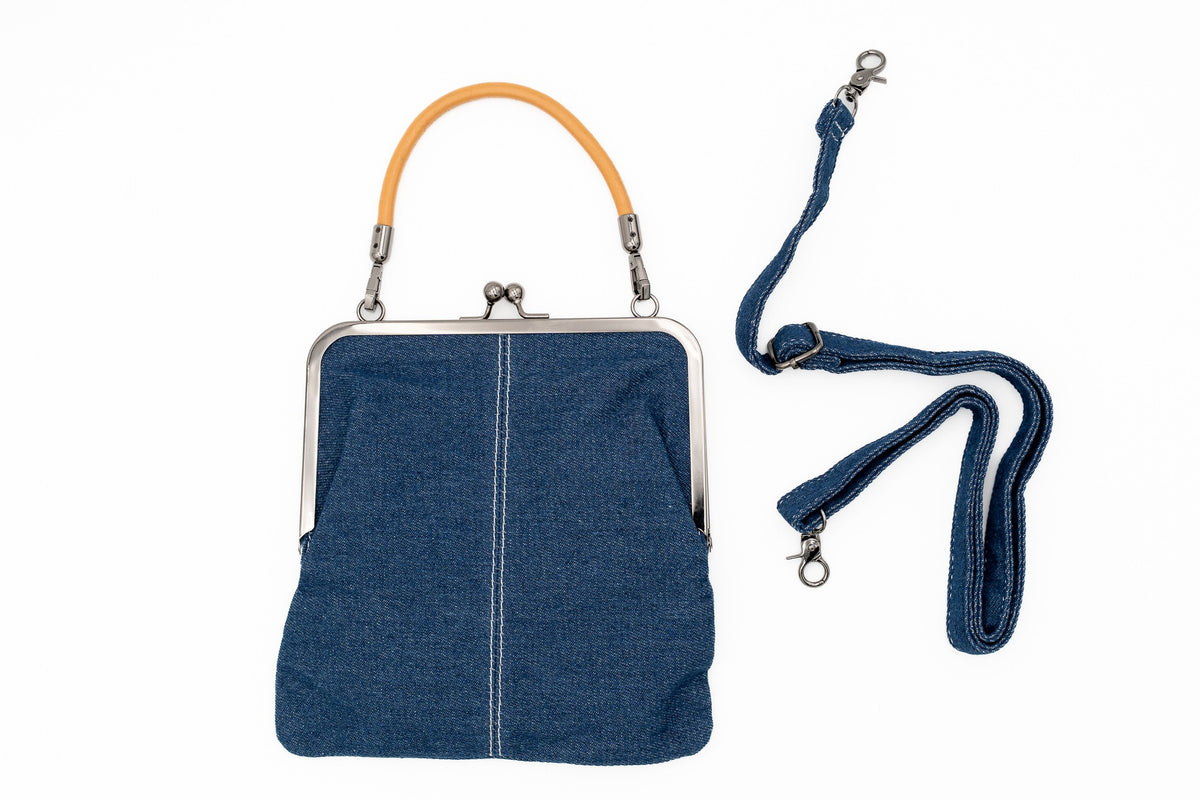 Denim-Handtasche mit Metallbügelverschluss und kurzem ockerfarbenem Henkel