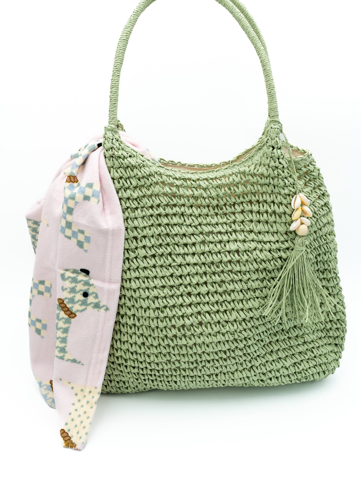 Geflochtene olivgrüne Hobo-Tasche mit Muschelquaste und rosa geometrischem Tuch.