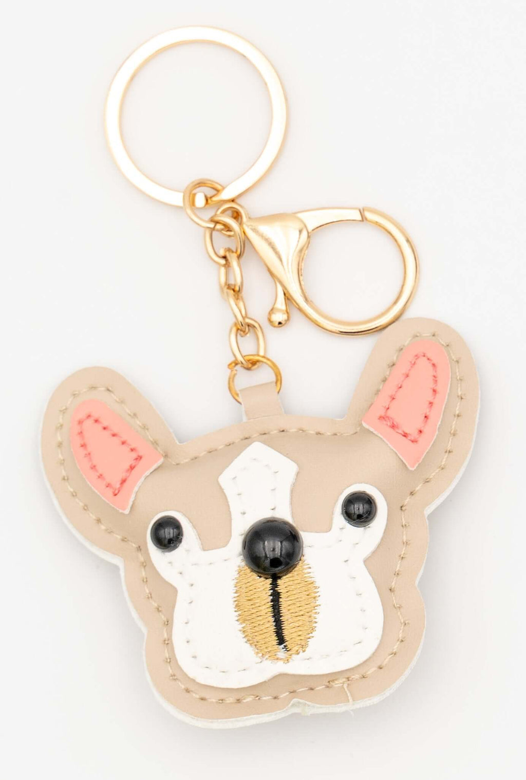 Llavero de perro pug en color beige con orejas rosadas y herrajes metálicos.