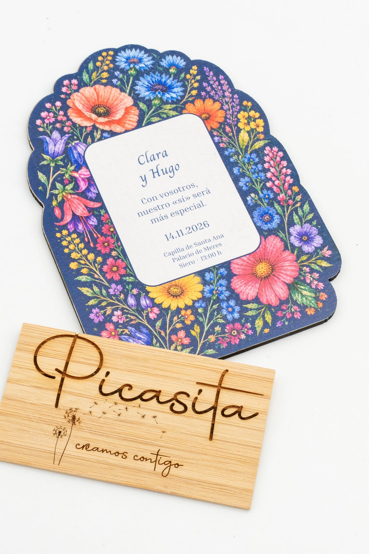 Hochzeitseinladung aus Holz mit bunten Wildblumen auf marineblauem Hintergrund