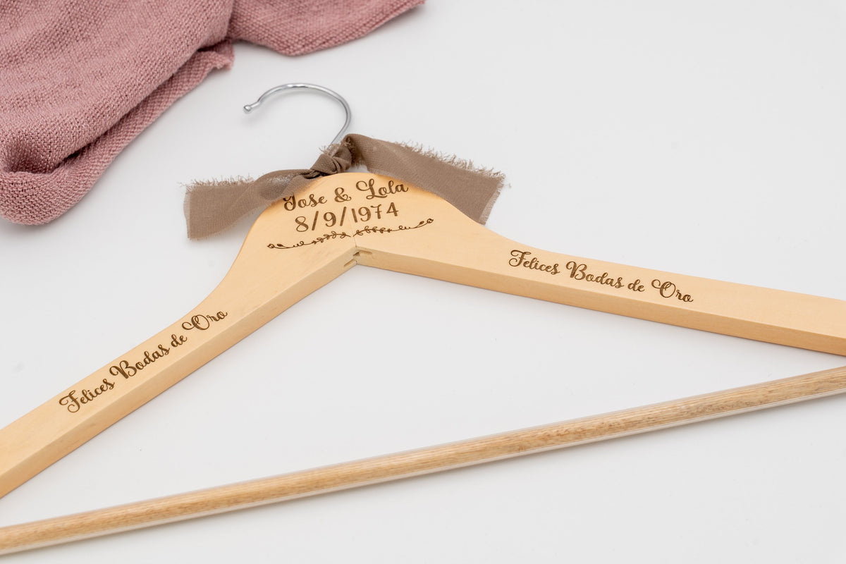 Kleiderbügel aus Holz mit den eingravierten Namen José und Lola und «Felices Bodas de Oro», mit brauner Schleife