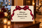 A3-Willkommensschild zur Hochzeit in Farbe, Design Lazo, mit Text auf Deutsch, auf einem Tischständer bei einem winterlichen Empfang.