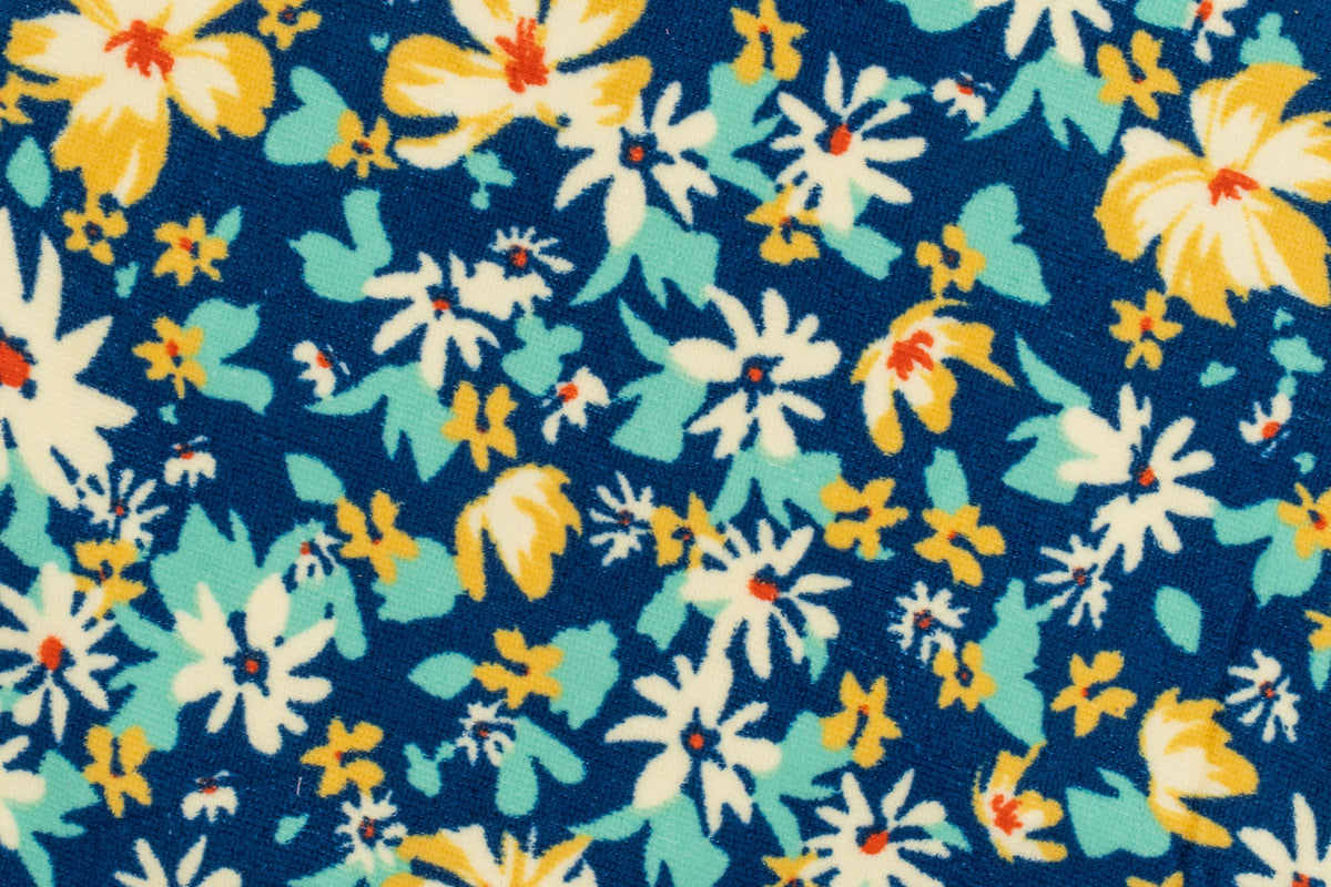 Nahaufnahme eines dunkelblauen Handtuchs mit aufgedruckten weißen und gelben Blumen.