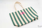 Tote bag de algodón con rayas verdes y blancas y personalización de iniciales en rosa.